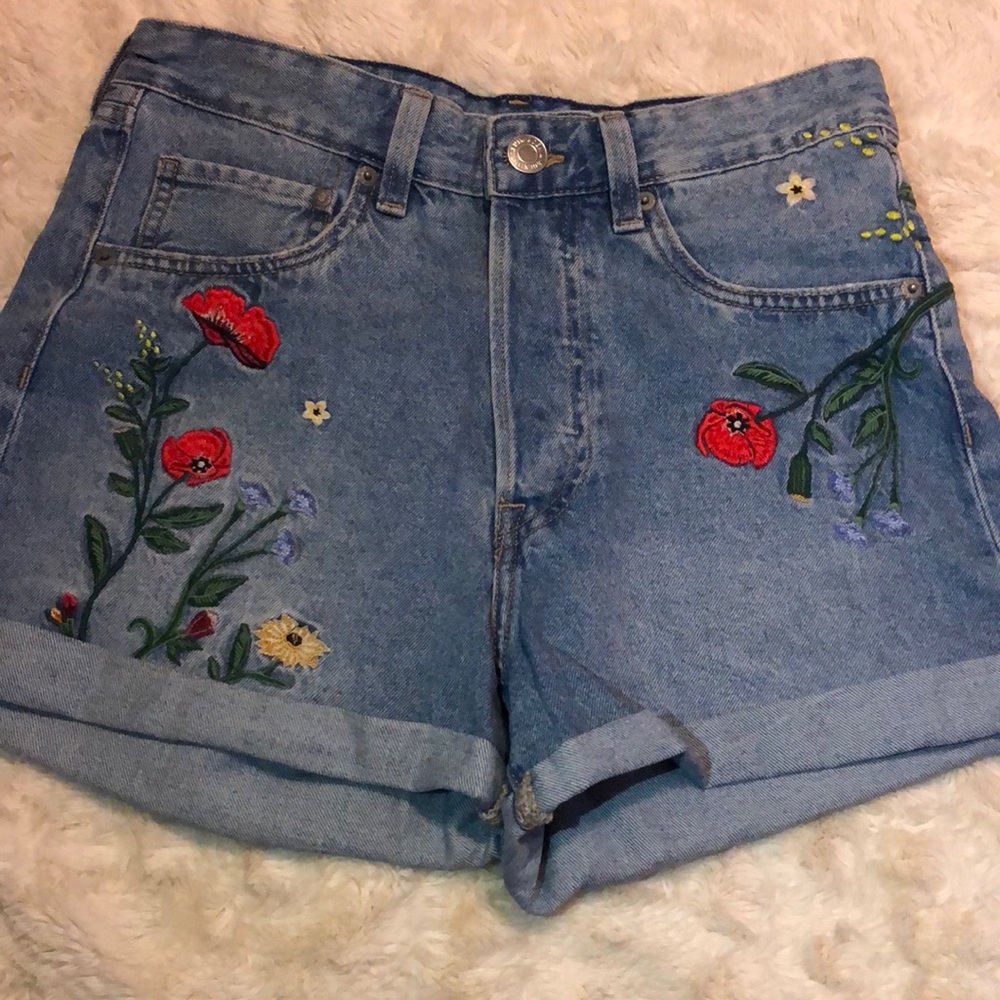 Denim shorts with floral designs.